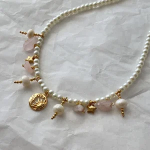 Collar rosa de perlas con dijes dorados